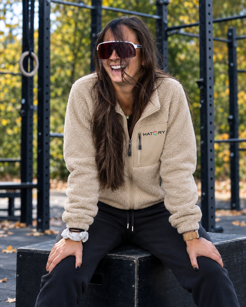 Frau in MATORY Sherpa Jacke Desert Dust auf einer Plyo-Box