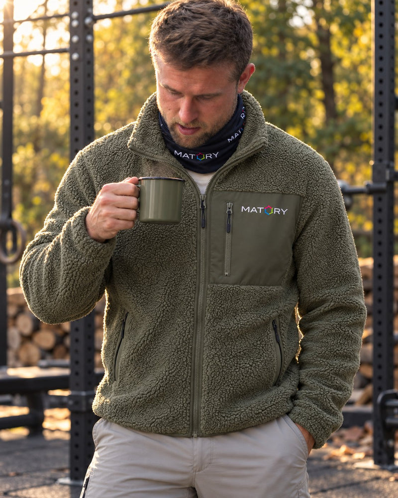 Mann in MATORY Sherpa Jacke Khaki mit Kaffeebecher