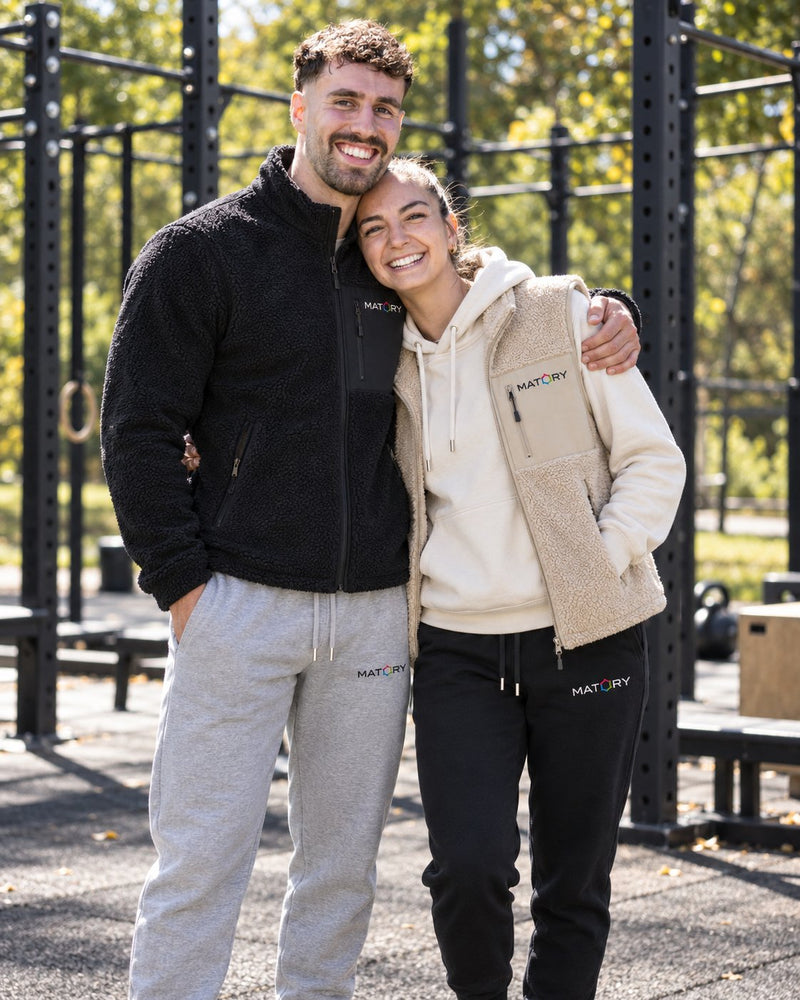 Paar in MATORY Sherpa Jacke, Hoodie Natural Raw und Weste Desert Dust